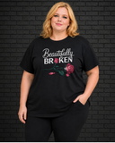 Plus size model wearing black crew neck shirt with Beautifully Broken design
