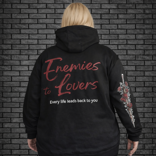 Plus size model wearing black oversized hoodie saying Enemies to Lovers